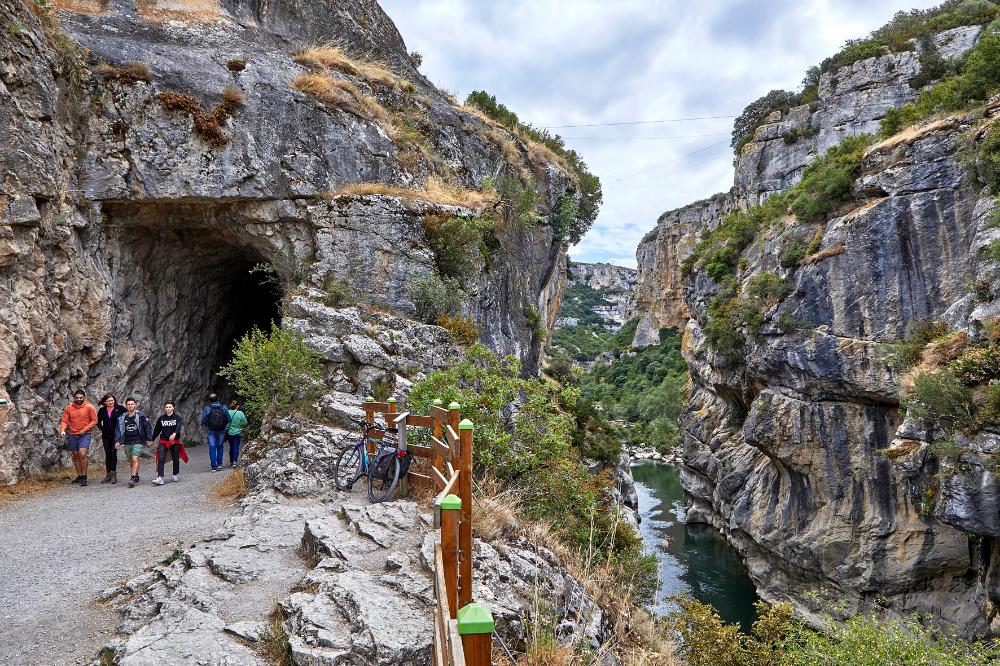 Entrada a la foz de Lumbier y personas entrando y saliendo del túnel